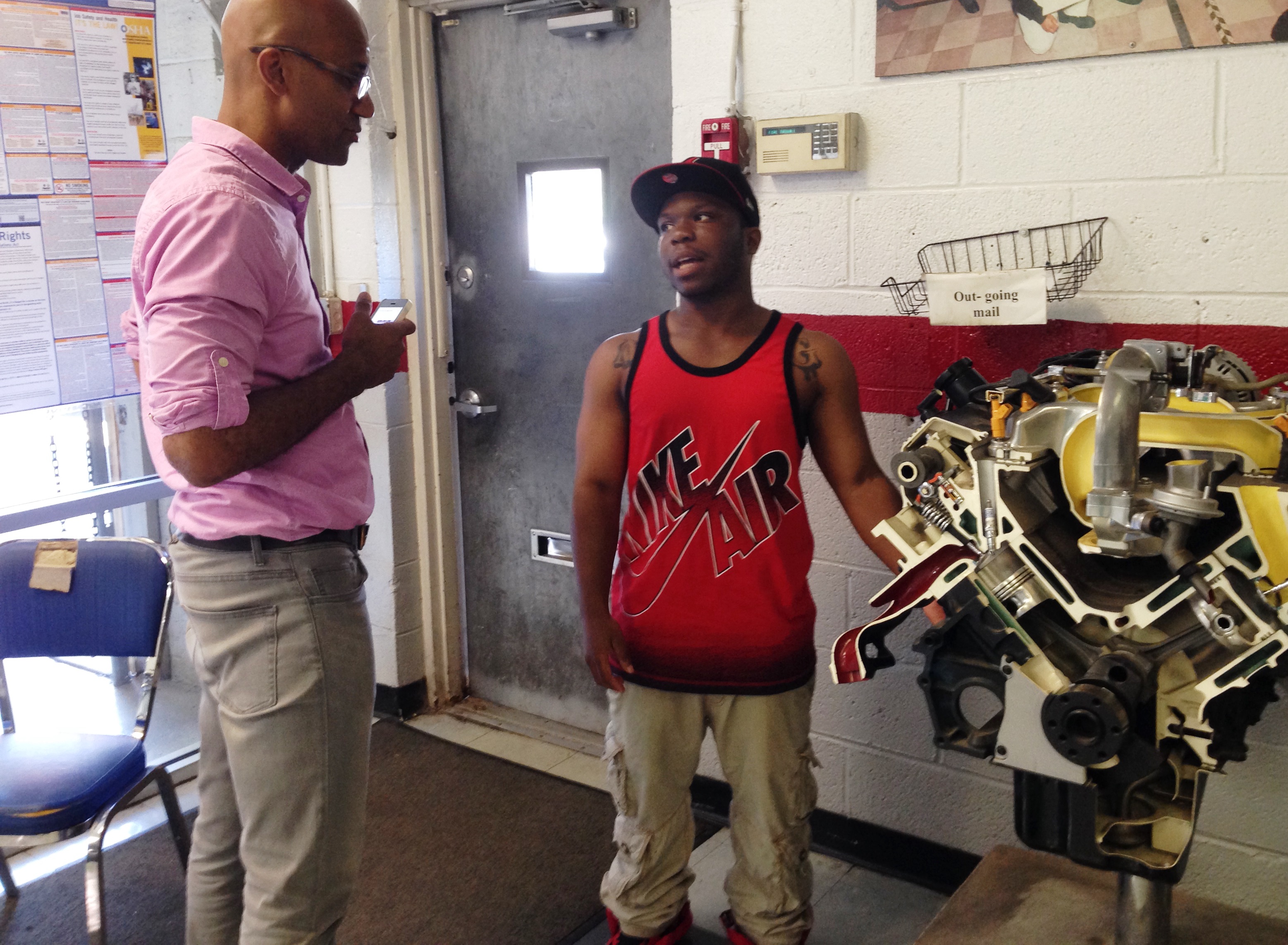 Dorian Moody, right, a recent student of NCC's Automotive Technician Employment and Training Program, speaks with Colorlines reporter Kai Wright, left.
