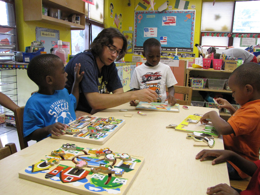 Augie Berkhardt, 16, solves puzzles with students at Community Hills Early Learning Center.