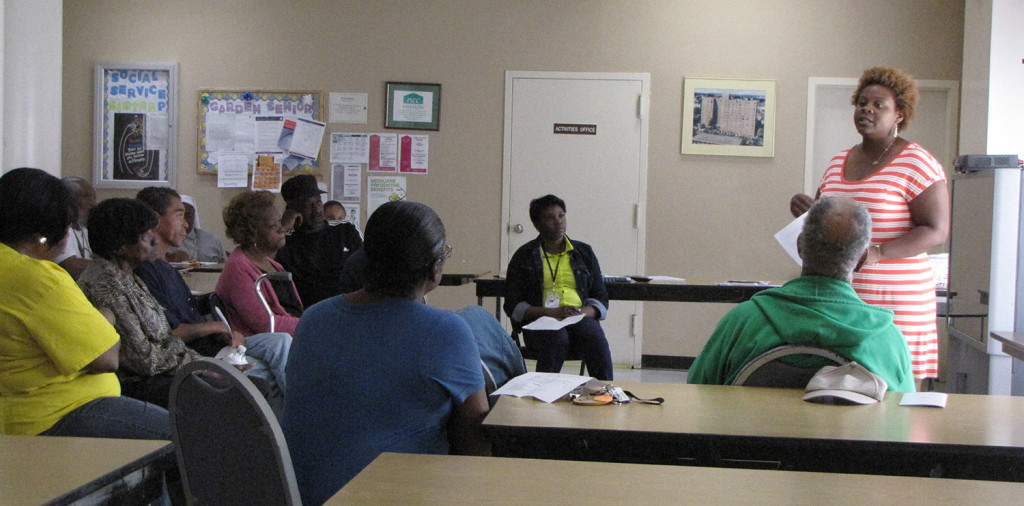 Aquilla Lowery, standing far right, an outreach navigator at the Hyacinth AIDS Foundation, spoke to New Community Gardens Senior residents about how to prevent HIV.