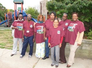 New Community is supporting the City of Newark’s effort to clean up and beautify its neighborhoods as part of a campaign called “Slam Dunk The Junk.” From left, Harmony House staff Linda Washington, Terrence Dhainy, Lisa Chavis, Carolyn Andrews, Melvina Coleman, Angela Hall and Angela Potts don t-shirts provided to NCC by the city that promote removing trash from the streets and planting flowers.