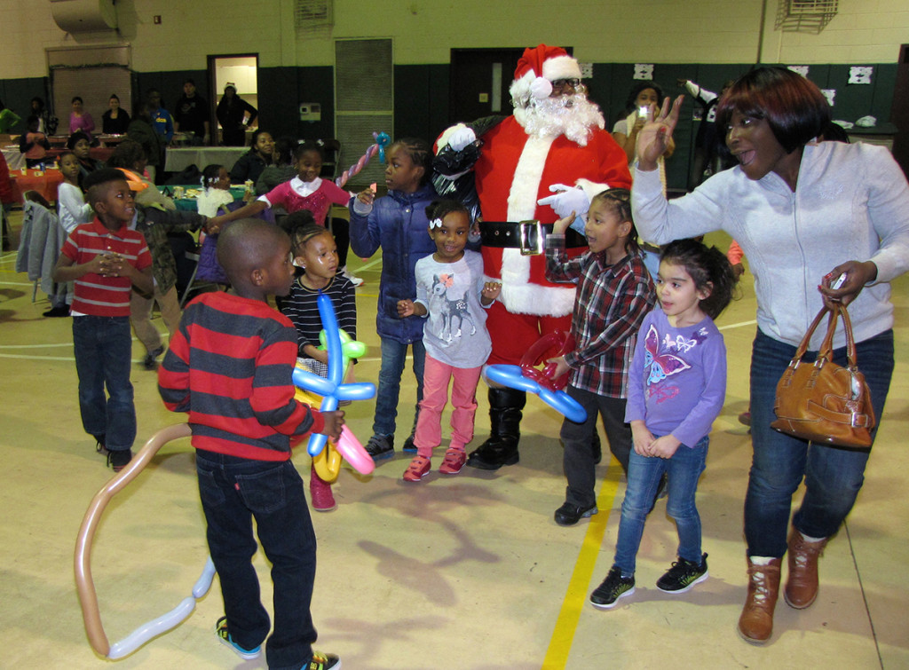 More than 200 children and their parents came to the Neighborhood Center on Hayes Street on the Saturday before Christmas for a complimentary breakfast and family photograph with Santa. Each child also received a gift.