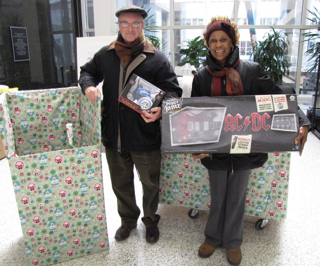 The Rev. Nicholas Gengaro, left, chaplain at Seton Hall University School of Law, displays about $3,000 worth of toys and gifts collected by SHU law students next to NCC Board Member Madge Wilson, who heads the annual toy drive.