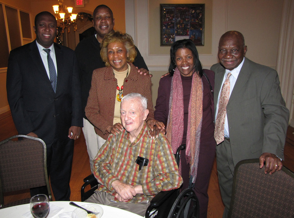 Board members, from left: Edgar Nemorin, Barry Baker, Madge Wilson, NCC Founder and Board Chairman Monsignor William J. Linder, Director of Property Management Fonda Porter, and Dr. A. Zachary Yamba gather for a holiday party at St. Joseph Plaza.