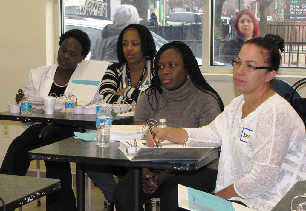 Staff from the New Community Extended Care Facility listen and take notes during a health literacy program held at the Family Service Bureau.