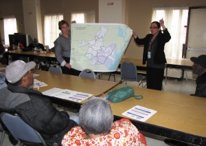 Joyce Sagi, left, and Tess Tomasi, right, of Disaster and Risk Associates, display a Hurricane Sandy flood map of the city of Newark to residents of Gardens Senior.