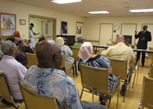 Rodd Henson, standing, of the firm Bermudez Henson, spoke to residents of New Community Orange Senior about Medicare and Medicaid.