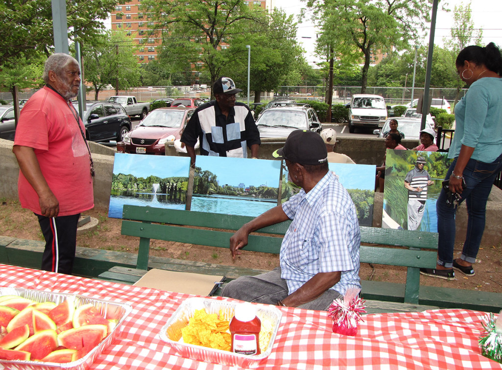 New Community Gardens Senior hosted a backyard barbecue at 265 Morris Ave. in Newark. Resident John Aytch, far left, puts his paintings on display.