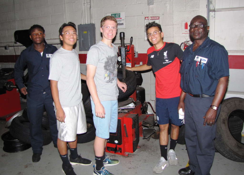 Students from St. Peter’s Prep learned how to change tires at the NCC Automotive Training Center, with instruction from John Zaccheus, far right, automotive instructor.