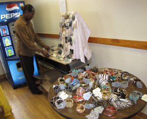 Angela Hall, youth coordinator at Harmony House, organizes the earrings and rings on display.