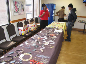 Case Manager Rachel Manyange, left, oversees a table display of jewelry.