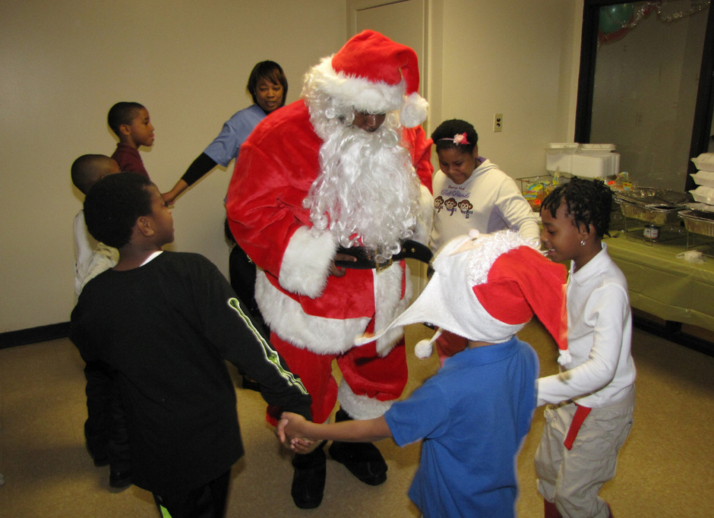 Santa Claus dances with the children whose families reside at New Community Sussex Gardens.