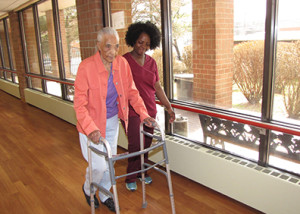 Toa Zoko, right, assists Extended Care resident Elizabeth Hairston during a session of rehabilitation therapy.