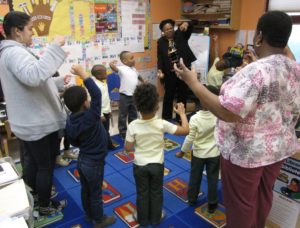 Pre-kindergarten students in Room 1 at Community Hills Early Learning Center stretch out an imaginary ball of “goop.”
