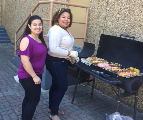 Care Coordinator Luz Toro, right, grills for a barbecue for residents at New Community Douglas Homes.