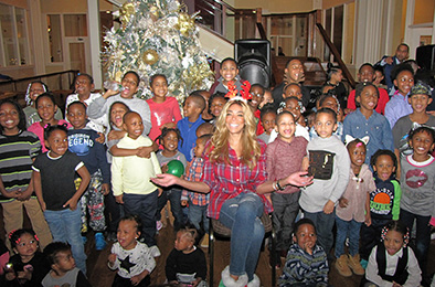Talk show host Wendy Williams, seated center, shares a moment with children from New Community.