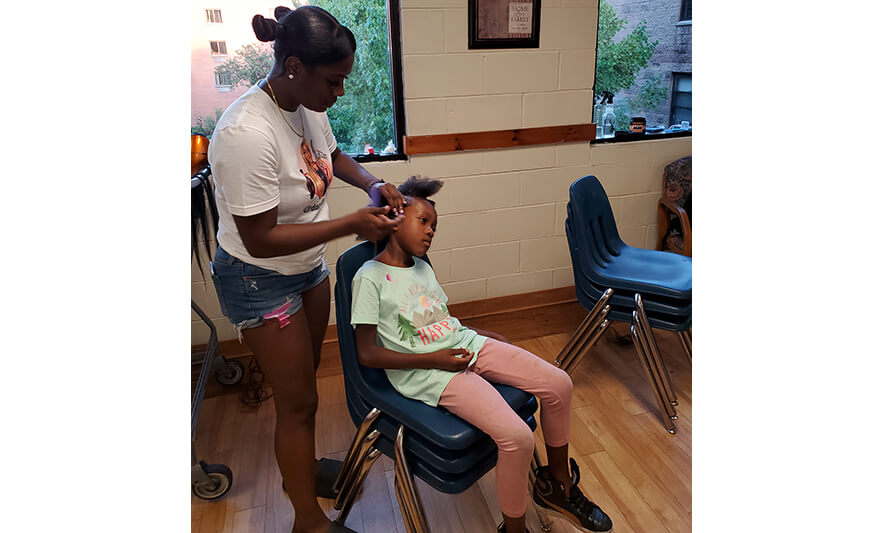 Harmony House Back to School 8-29-2022 Girl getting hair done from Yonette Fredericks for web