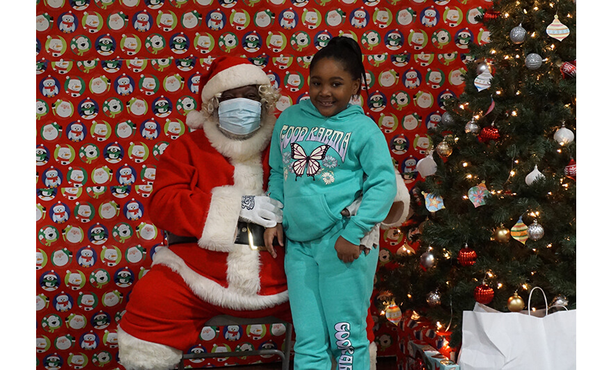 Breakfast with Santa 12-17-2022 Girl in butterfly shirt with Santa for web