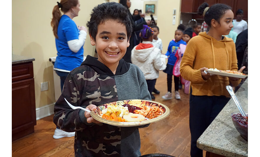 Withum Harmony House Thanksgiving Dinner 11-21-2022 Boy smiling with plate for web
