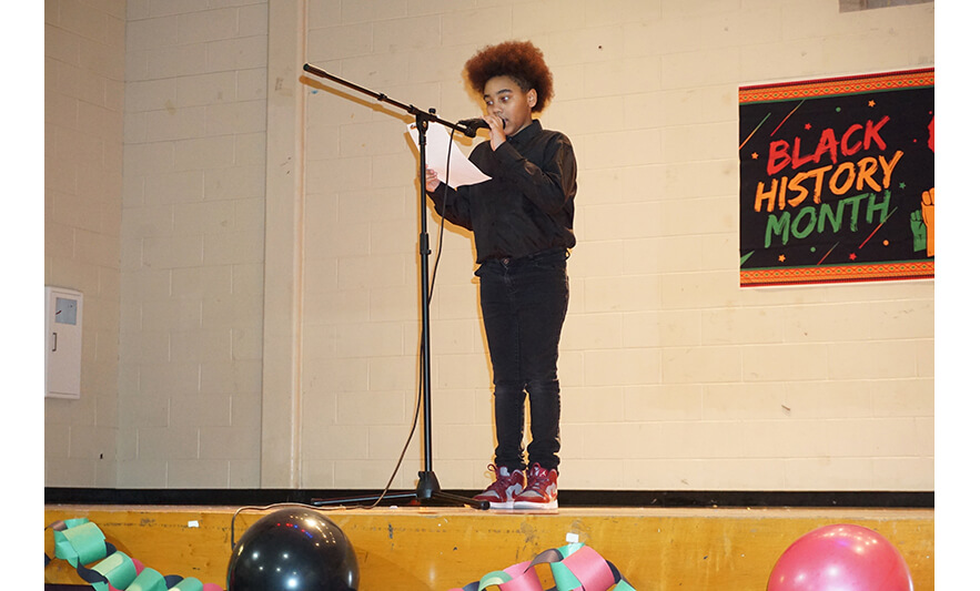 Youth Services Black History Month Program 2-24-2023 Boy in black holding mic for web