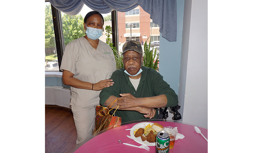 Extended Care Adopt-A-Resident Day 5-17-2023 Staff member with man in green for web