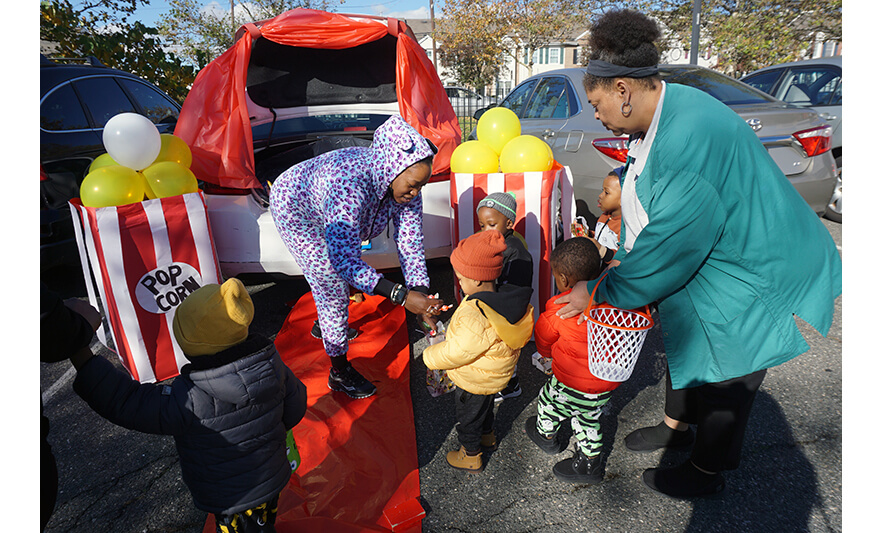 CHELC Trunk or Treat 10-31-2023 Woman handing out candy at popcorn trunk for web