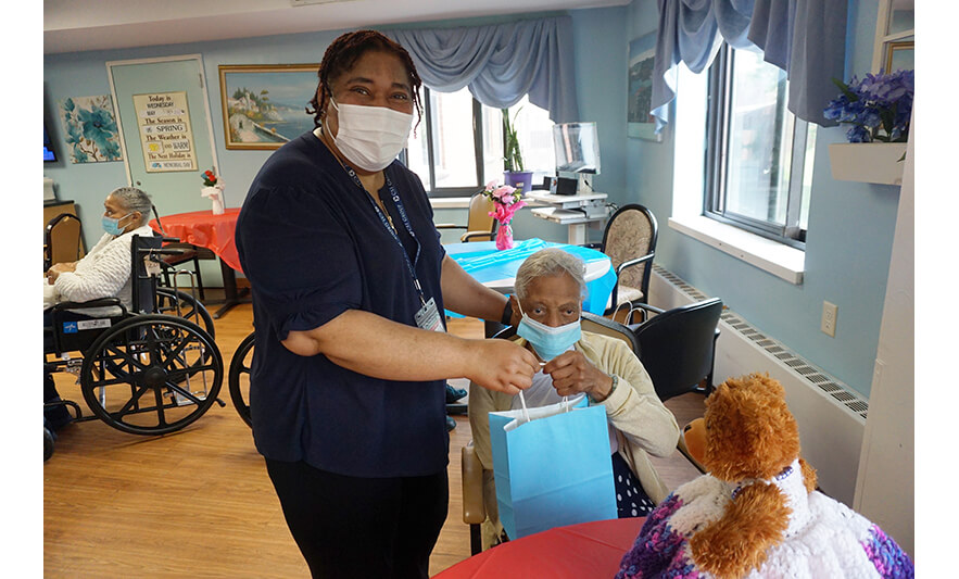 Extended Care Adopt-a-Resident Day 5-15-2024 Christiana Agbozo giving blue bag for web